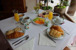 a table with plates of breakfast foods and orange juice at Moderna do Geres Hotel in Geres