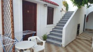 a stairway with two chairs and a table and a door at Aeolos Hotel Apartments in Gythio