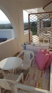 a room with a table and a bench and a table and chairs at Aeolos Hotel Apartments in Gythio