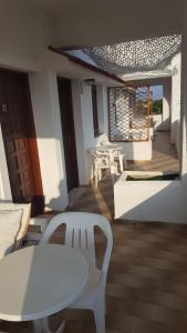a patio with a white table and chairs and a window at Aeolos Hotel Apartments in Gythio