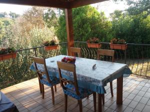 a table and chairs on a porch with flowers on it at B&B Land & Sea in Campofilone