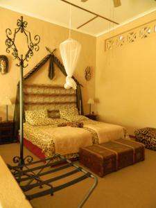 a bedroom with a bed with a canopy and a trunk at Corona Guest Farm in Corona