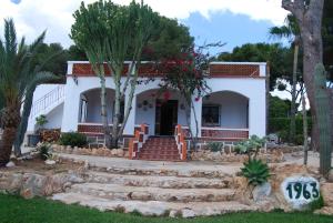 una casa blanca con palmeras delante en Villa Maria Beach Villa, en Moraira