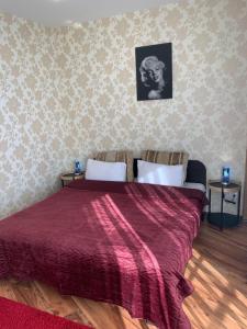 um quarto com uma cama grande e um cobertor vermelho em Most City Riverview em Dnipro