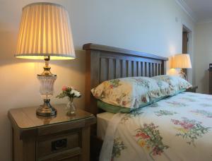 una camera da letto con un letto con una lampada sul comodino di Conway's Cottage with Sea View Nestling by Cliffs-of-Moher a Liscannor