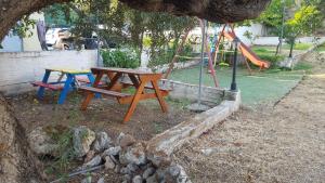 a picnic table in a park with a playground at Aeolos Hotel Apartments in Gythio