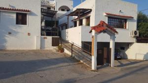 a white building with a gate in front of it at Aeolos Hotel Apartments in Gythio