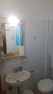 a white bathroom with a sink and a toilet at Aeolos Hotel Apartments in Gythio