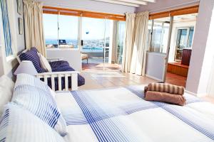 a bedroom with a large bed with a view of the ocean at Simonstown Penthouse in Simonʼs Town