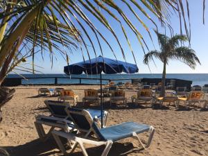 Playa del AguilaにあるExclusive Apartmentの浜辺の椅子・傘