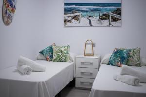 贝尼多姆APARTAMENTO EN EL CENTRO A UN MINUTO DE LA PLAYA的一张位于一间享有大海美景的客房内的两张床