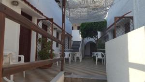 a balcony with tables and chairs in a building at Aeolos Hotel Apartments in Gythio