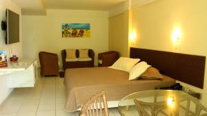 una camera con letto, tavolo e sedie di Natal Praia Hotel a Natal