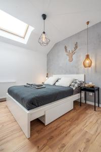 sypialnia z dużym białym łóżkiem w pokoju w obiekcie Gold Apartments Your Holiday Home RODZINNY 27 w mieście Krynica Zdrój
