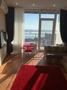 - un salon avec un canapé et une table avec un tapis rouge dans l'établissement Most City Riverview, à Dnipro