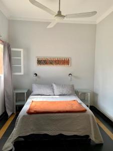 a bedroom with a bed with an orange blanket on it at Continental Hotel in Curuzú Cuatiá