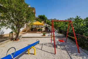 a playground with a slide and a swing set at Apartments Josip in Trogir
