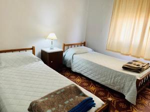 um quarto com 2 camas, um candeeiro e uma janela em Continental Hotel em Curuzú Cuatiá
