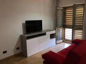 a living room with a tv on a white entertainment center at B&B Altamarea in Falerna