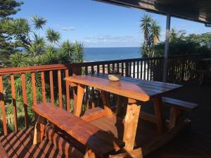 a wooden picnic table and a bench on a deck at Illovo Beach Inn in Amanzimtoti