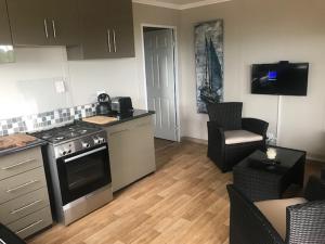 a kitchen with a stove and a living room at Illovo Beach Inn in Amanzimtoti
