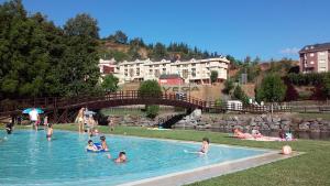 a group of people swimming in a swimming pool at Casa de la Playa in Vega de Espinareda