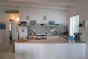 a kitchen with a counter and a refrigerator at Palm Villa Cottage in Kommetjie