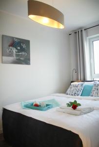 een slaapkamer met een bed met twee borden eten erop bij Apartament Blue Paradise in Kołobrzeg