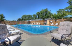 a pool with chaise lounge chairs and a swimming pool at Windrift Motel in West Yarmouth