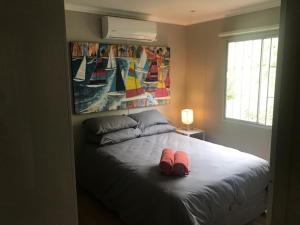 a bedroom with a bed with two shoes on it at Illovo Beach Inn in Amanzimtoti