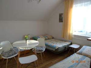 スバジェボにあるPokoje gościnne Olkaのテーブルと椅子、テーブルとベッドが備わる客室です。