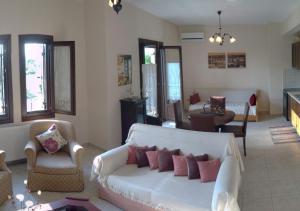 un soggiorno con divano e sedie bianchi di Harmony seaside apartments a Koropi