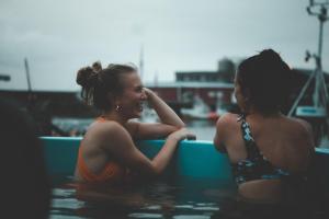 two women are sitting in the water at Solsiden Brygge Rorbuer in Ballstad