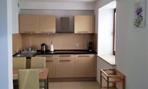 una cocina con armarios de madera y una mesa con mesa. en Apartament Nadmorski en Sarbinowo