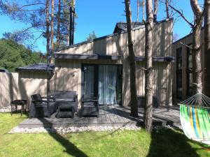 a house with a deck with a table and chairs at Jūros perlas in Palanga