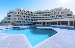 duży budynek z dużym basenem przed nim w obiekcie UMH Tarik Hotel w mieście Tanger