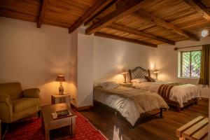 a bedroom with two beds and a chair and a window at Hospedaje Rural Casa Mallqui in Leimebamba