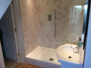 a bathroom with a shower and a sink at Aberllynfi Riverside Guest House in Glasbury