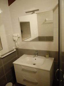 La salle de bains est pourvue d'un lavabo blanc et d'un miroir. dans l'établissement B&B Villa Di Bartolomeo, à Capaccio-Paestum