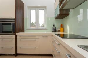 a kitchen with white cabinets and a window at Seafront Apartment Soline With Seaview in Soline