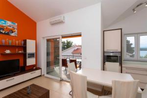 a dining room with a white table and chairs at Seafront Apartment Soline With Seaview in Soline