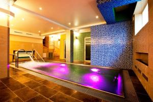 una piscina cubierta en una casa con luces moradas en Relax Inn en Praga