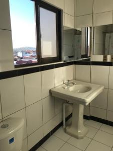 a bathroom with a sink and a toilet at Cittadella Hostal in Sucre