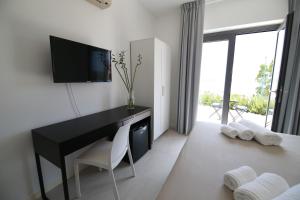 ポルト・エンペードクレにあるVilla Martorana, Camere e Appartamenti Short Let'sの机とテレビがあるホテルの部屋