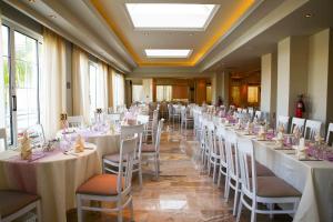 a banquet hall with white tables and chairs at Margarita Hotel - All Inclusive in Laganas