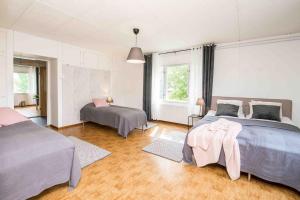 a large bedroom with two beds and two windows at Villa Sjöman - with seaview in Alskat