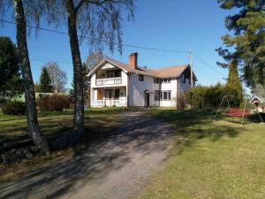 een groot wit huis met bomen en een onverharde weg bij Villa Sjöman - with seaview in Alskat