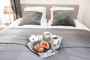 een ontbijtpakket met donuts en twee kopjes op een bed bij Villa Sjöman - with seaview in Alskat