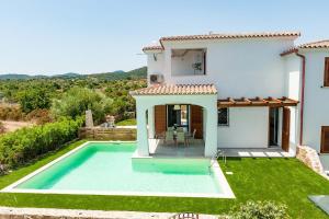 a villa with a swimming pool in front of a house at VILLA PARADISE in Budoni