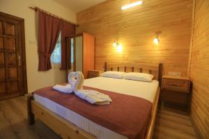 a bedroom with a bed with towels on it at Tunays Pansiyon in Cıralı